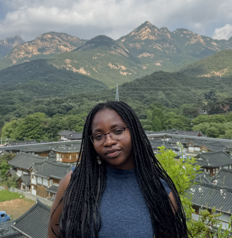 Profile Photo of Promise Adeliyi with a backdrop of a bright blue sky and big mountains in the distance