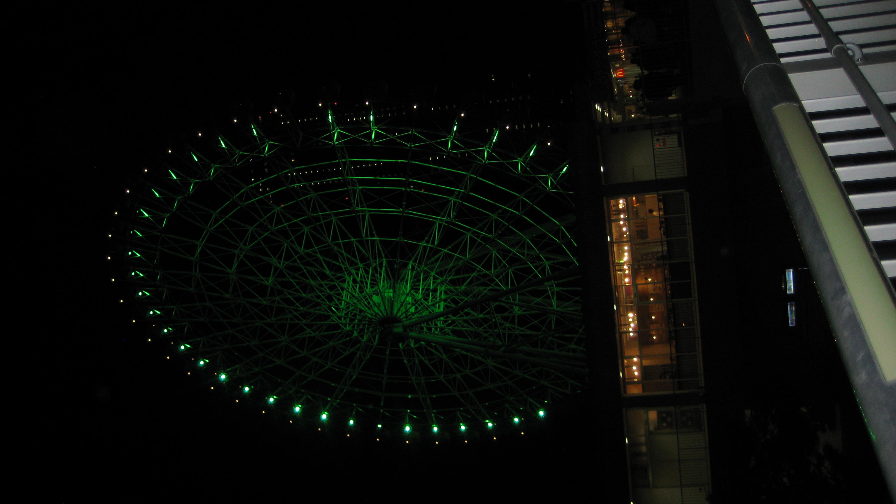 picture of a green light ferris wheel at night